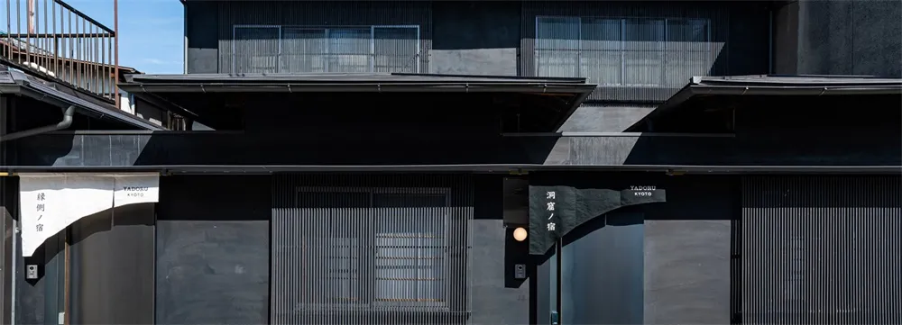 A modern building facade with metal panels and a blurred background.