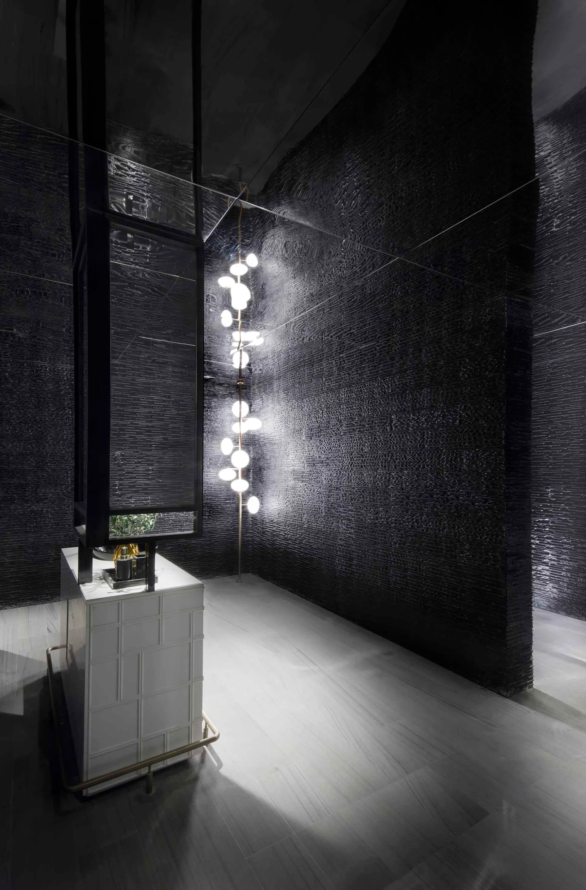 Modern lobby with textured black tiles and concrete elements