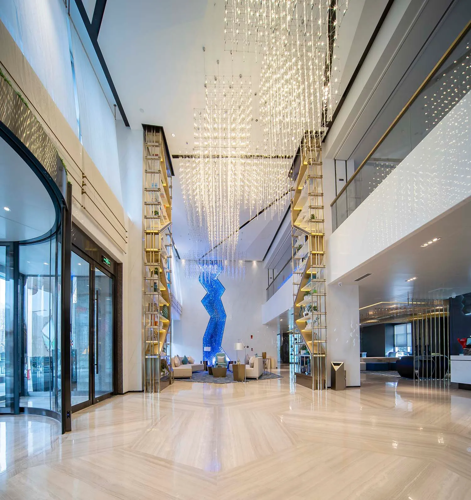 A modern hotel lobby with glass fixtures and elegant lighting features.
