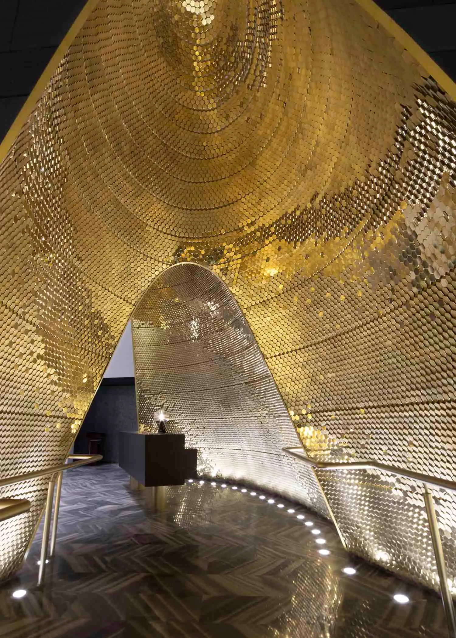 A modern architectural interior featuring metallic panels with a geometric design.