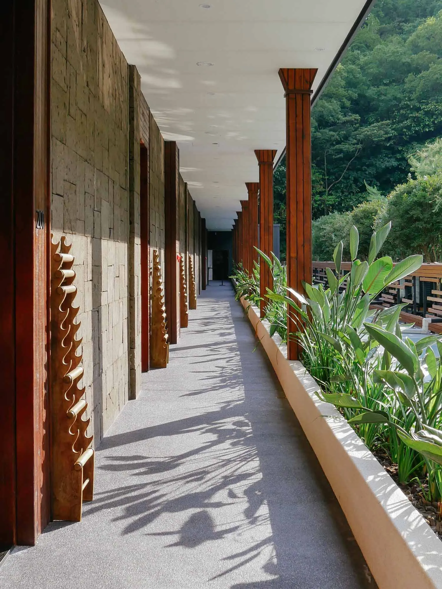 A scenic corridor lined with stone walls and concrete walkway.