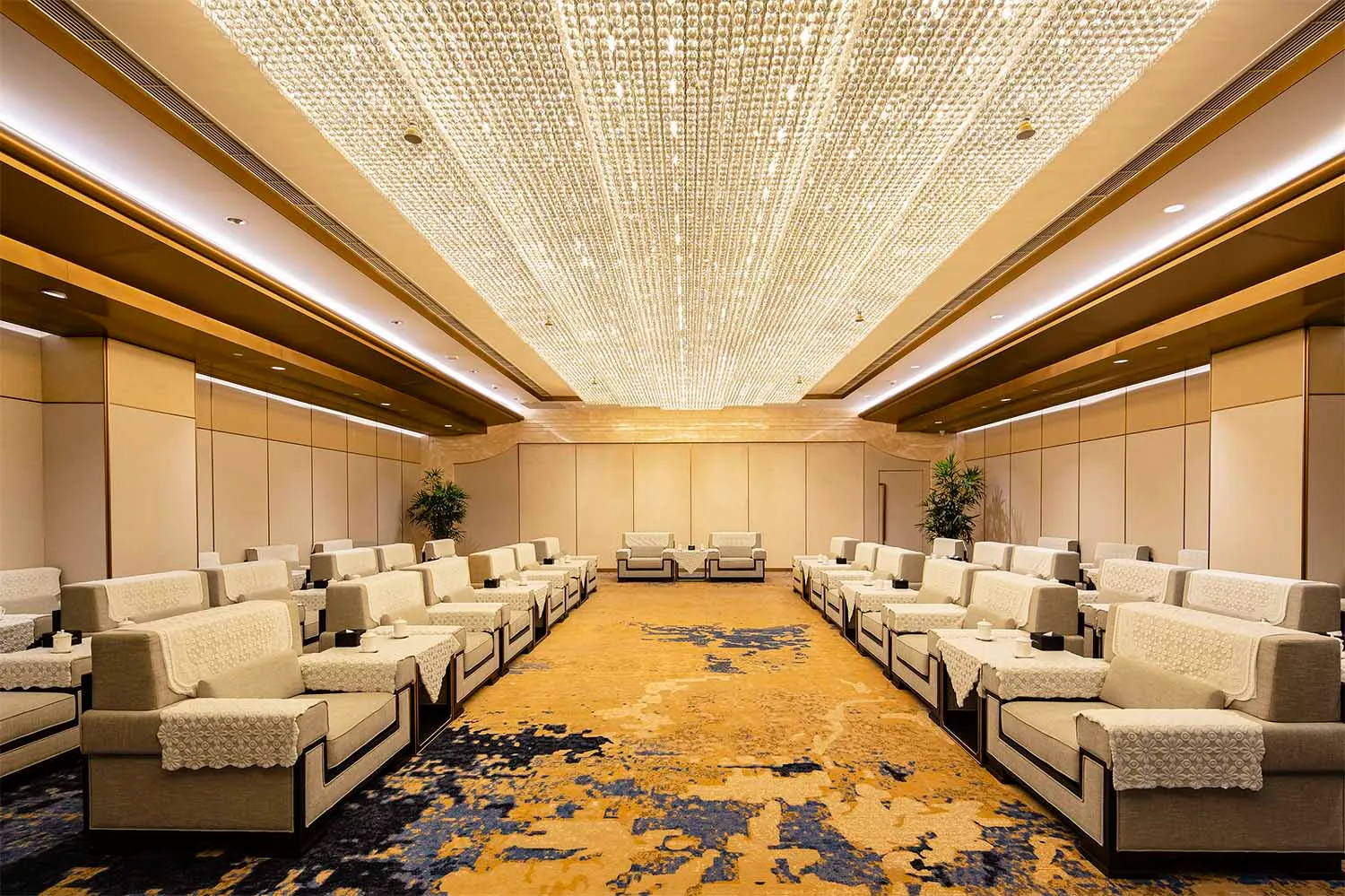 An interior image of an event hall with sofas arranged in rows.