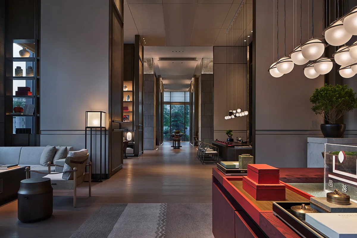 A minimalist hotel lobby featuring modern furniture and lighting.