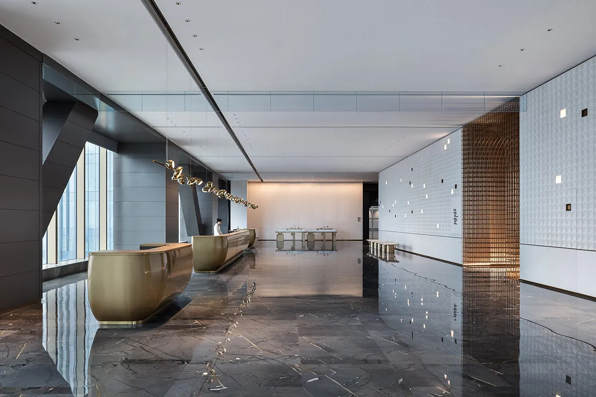 Modern hotel lobby featuring marble and metal surfaces.