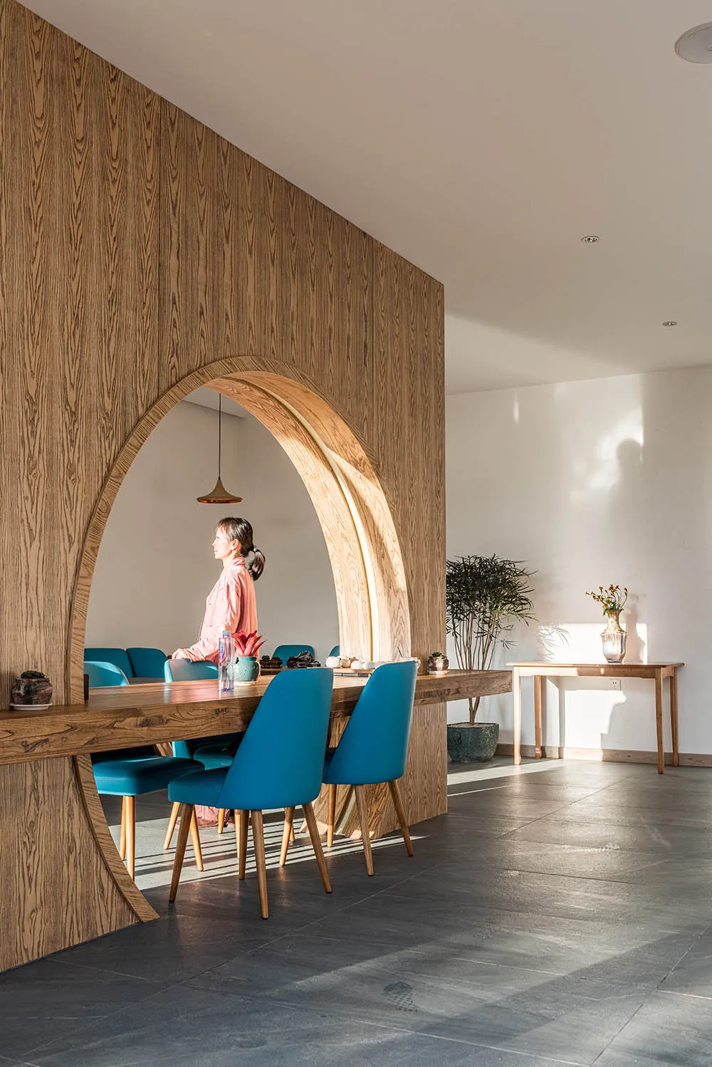 A modern interior design featuring a wooden table and blue chairs.