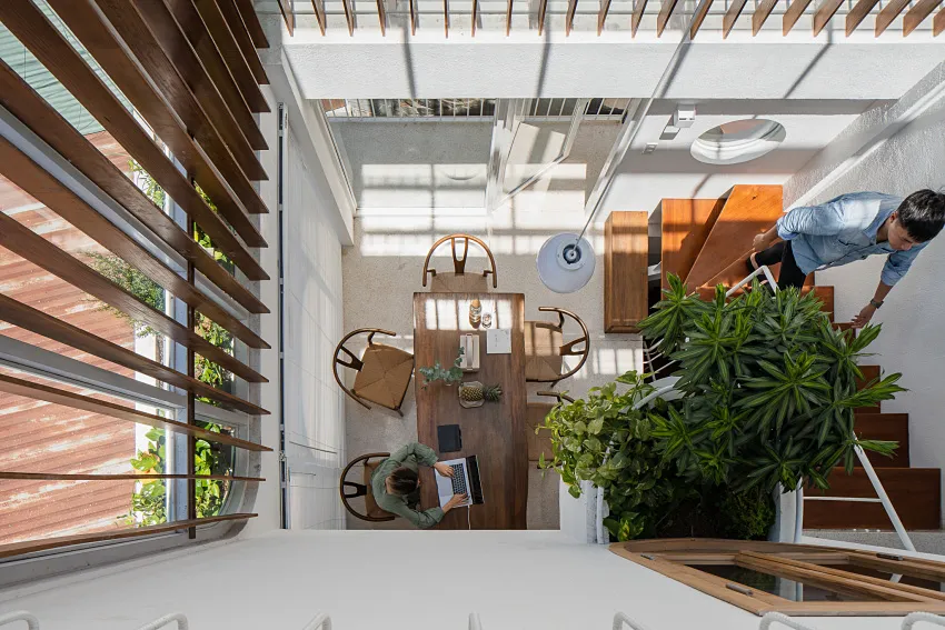A modern industrial dining area featuring a wooden table, chairs, and concrete accents.