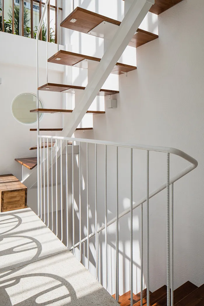 A modern staircase with concrete steps, steel railings, and wooden treads.