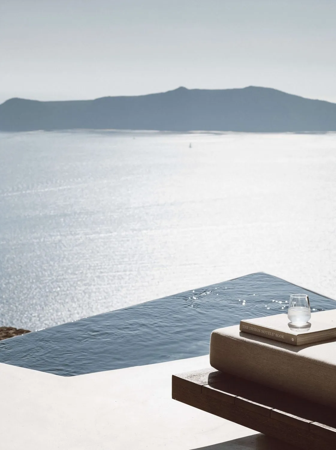 A minimalist holiday villa with a concrete structure and a view of the serene sea.