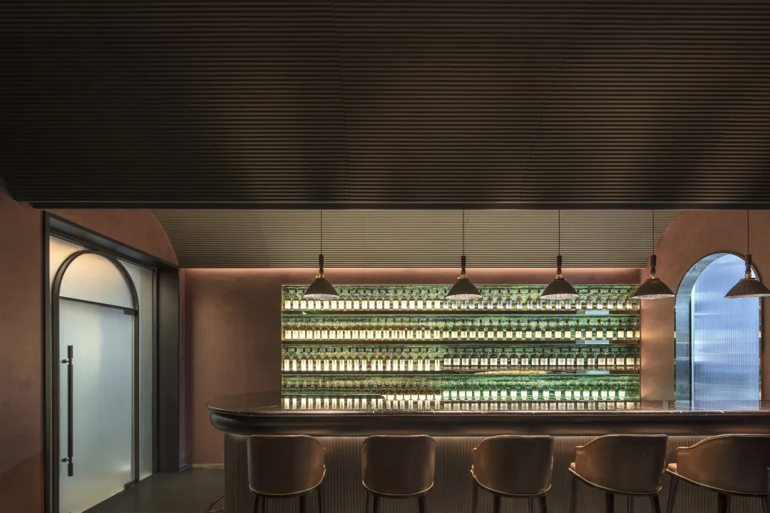 Modern bar interior featuring metallic shelves and light fixtures.