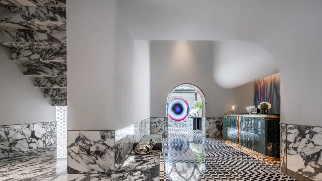 Interior view of a modern hotel lobby featuring marble flooring and a reception desk.