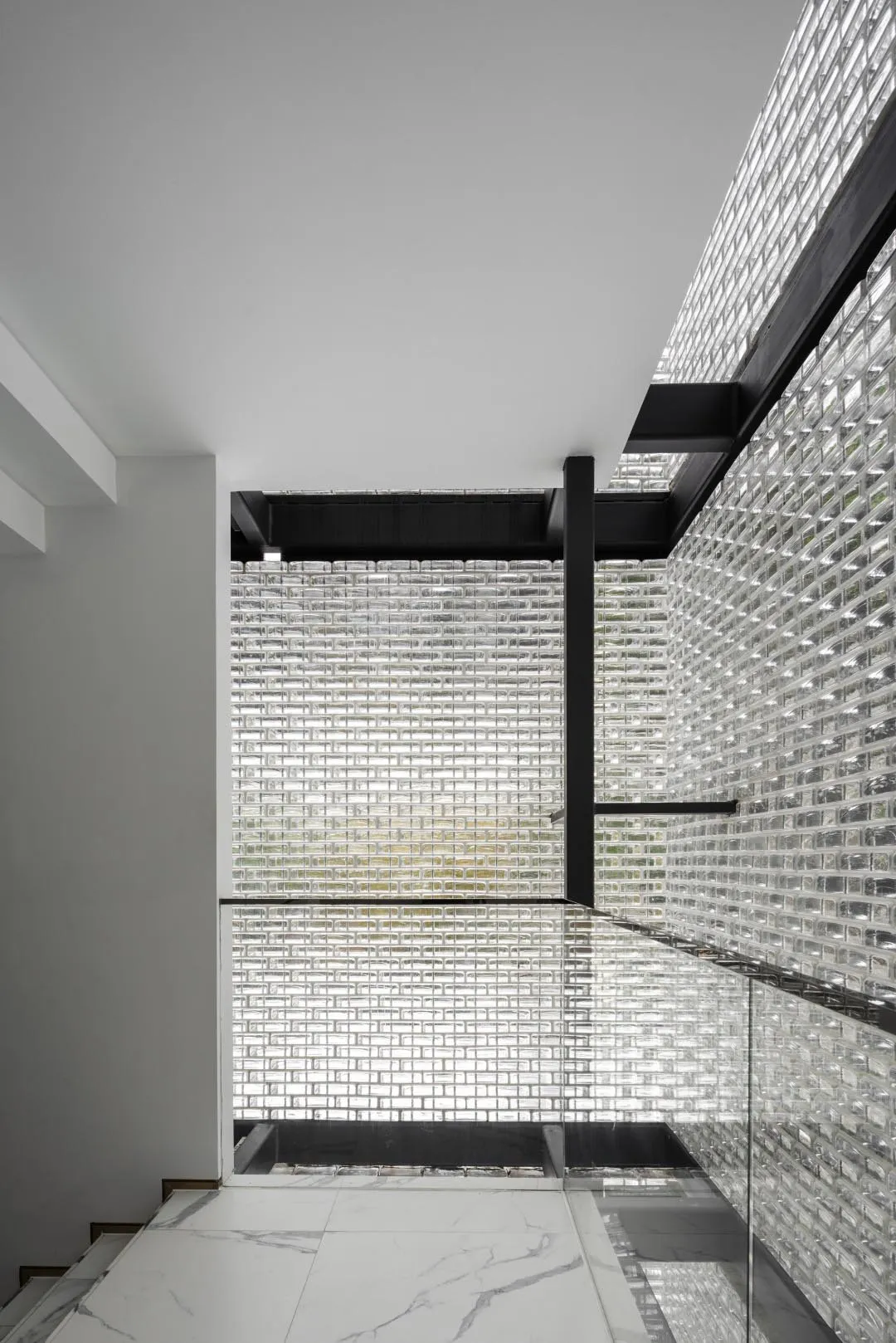 Minimalist interior with white marble floors and glass wall