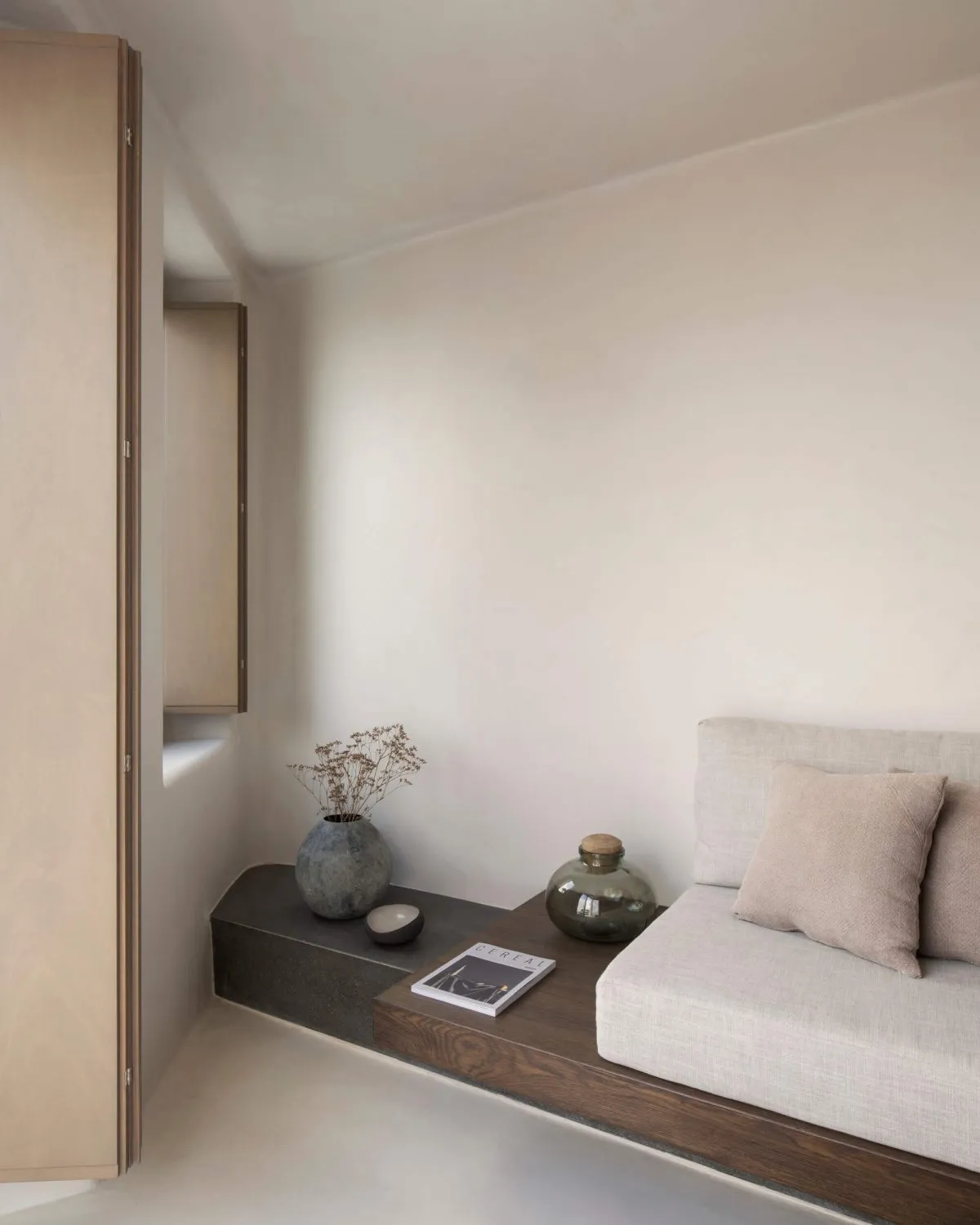 Modern minimalist living space featuring concrete and wood elements.