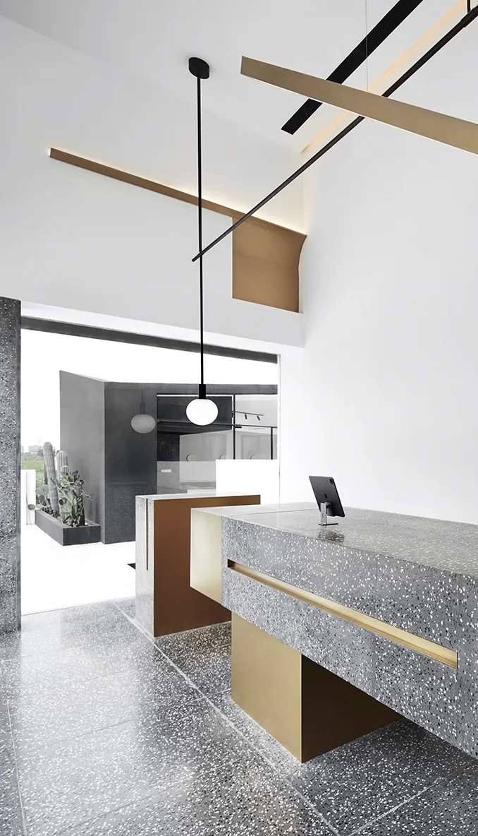 Modern retail cafe interior with a concrete and terrazzo counter featuring brass accents.