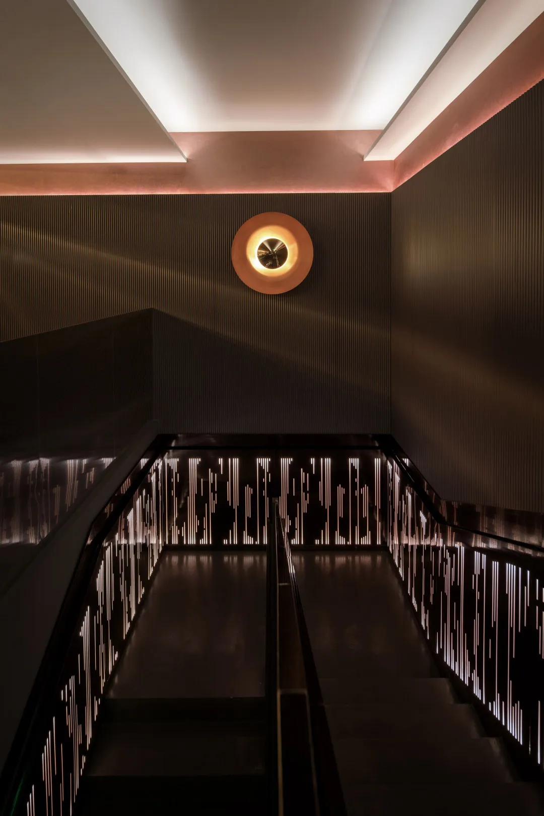Modern staircase featuring illuminated metal railings and steps.