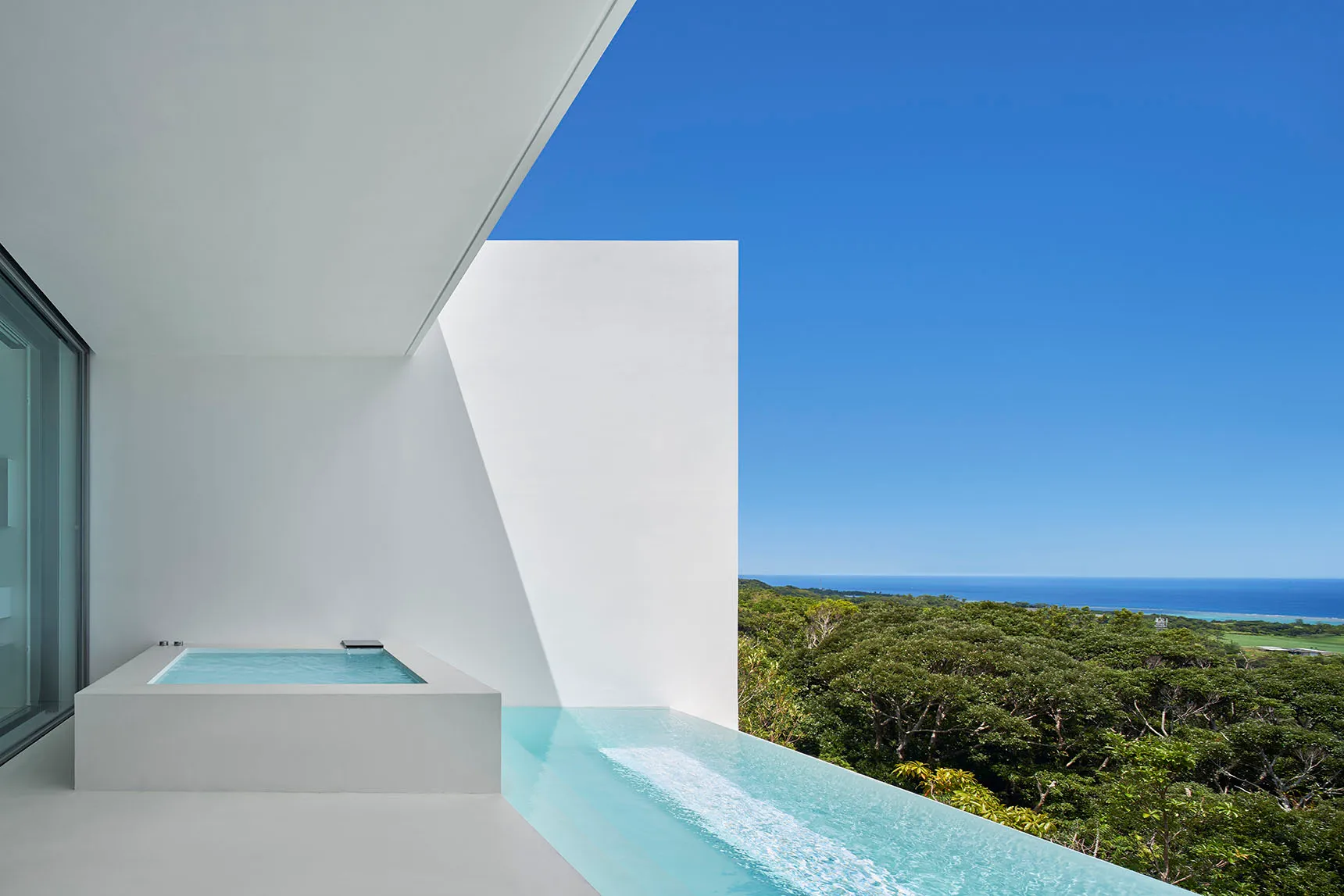 Modern residential patio featuring glass and concrete materials.
