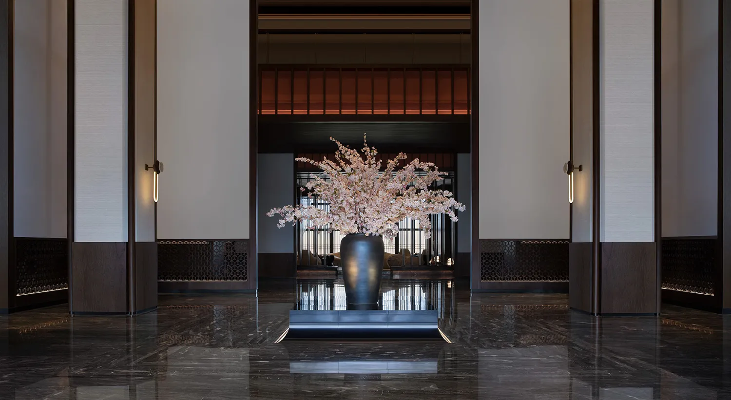 現代酒店大廳,鋪設大理石地板,擺放黑色花瓶與粉色花朵。