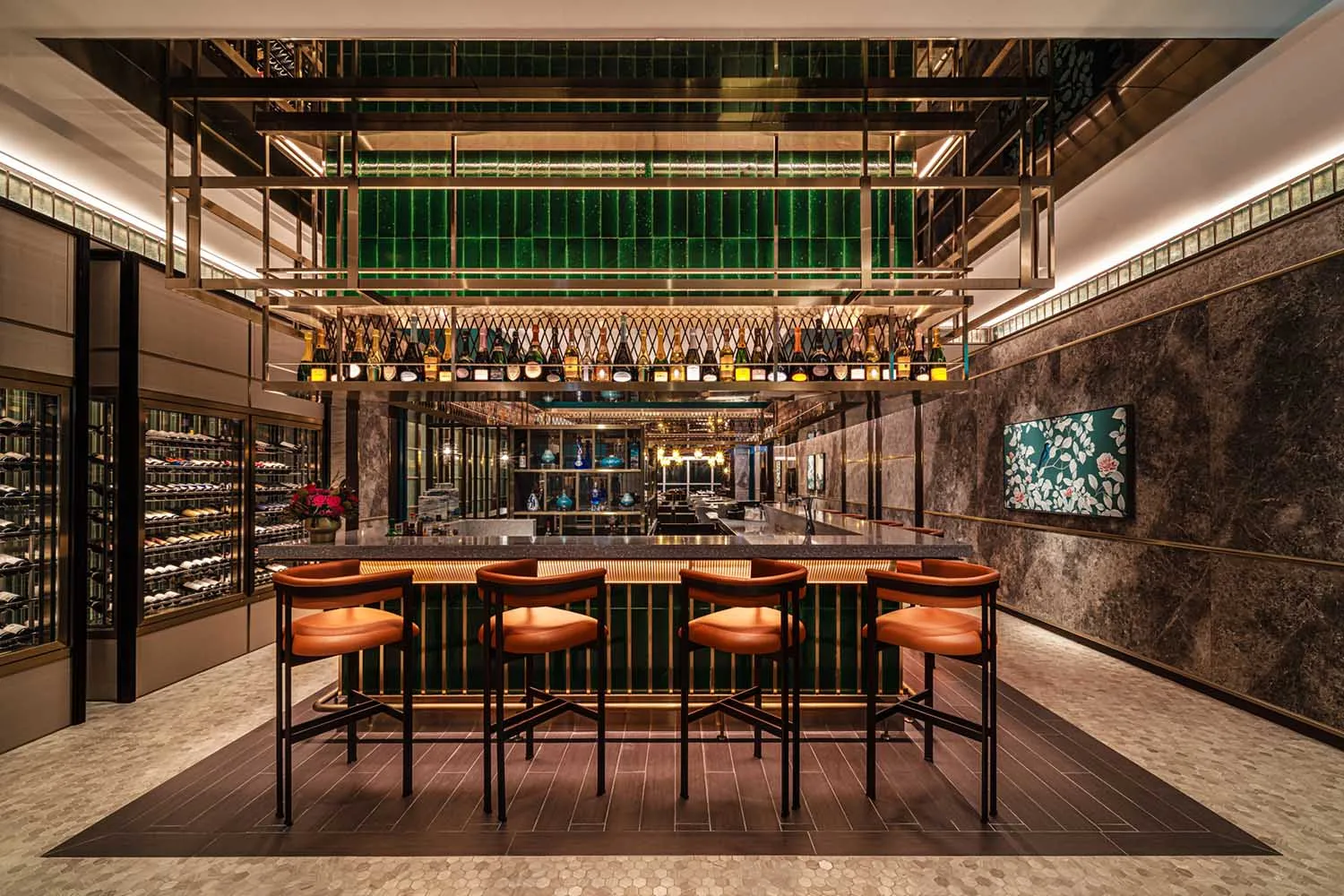 Modern bar with marble and glass materials, featuring metal railings and a variety of bottles.