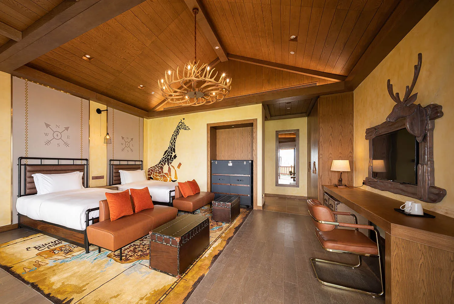 A modern hotel bedroom featuring a wooden interior design with a king-sized bed, twin beds, and a work desk.