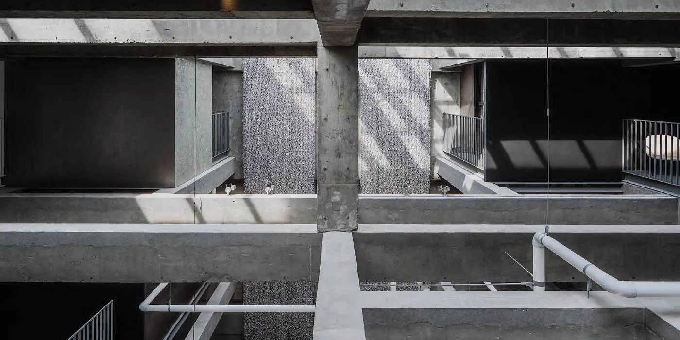 An overhead view of a minimalist office space with concrete walls and floors.