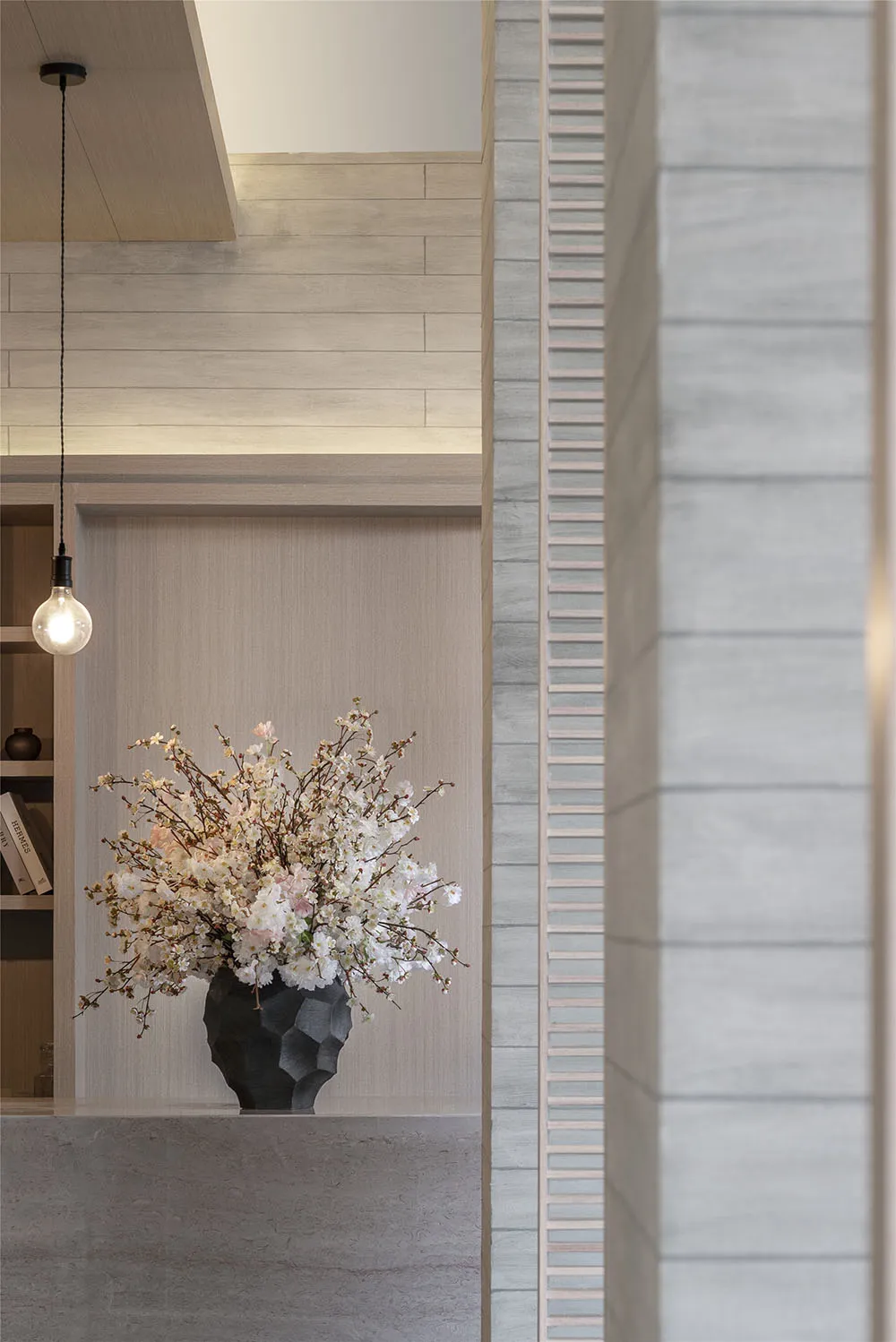 A ceramic vase with white and pink flowers in a modern interior space