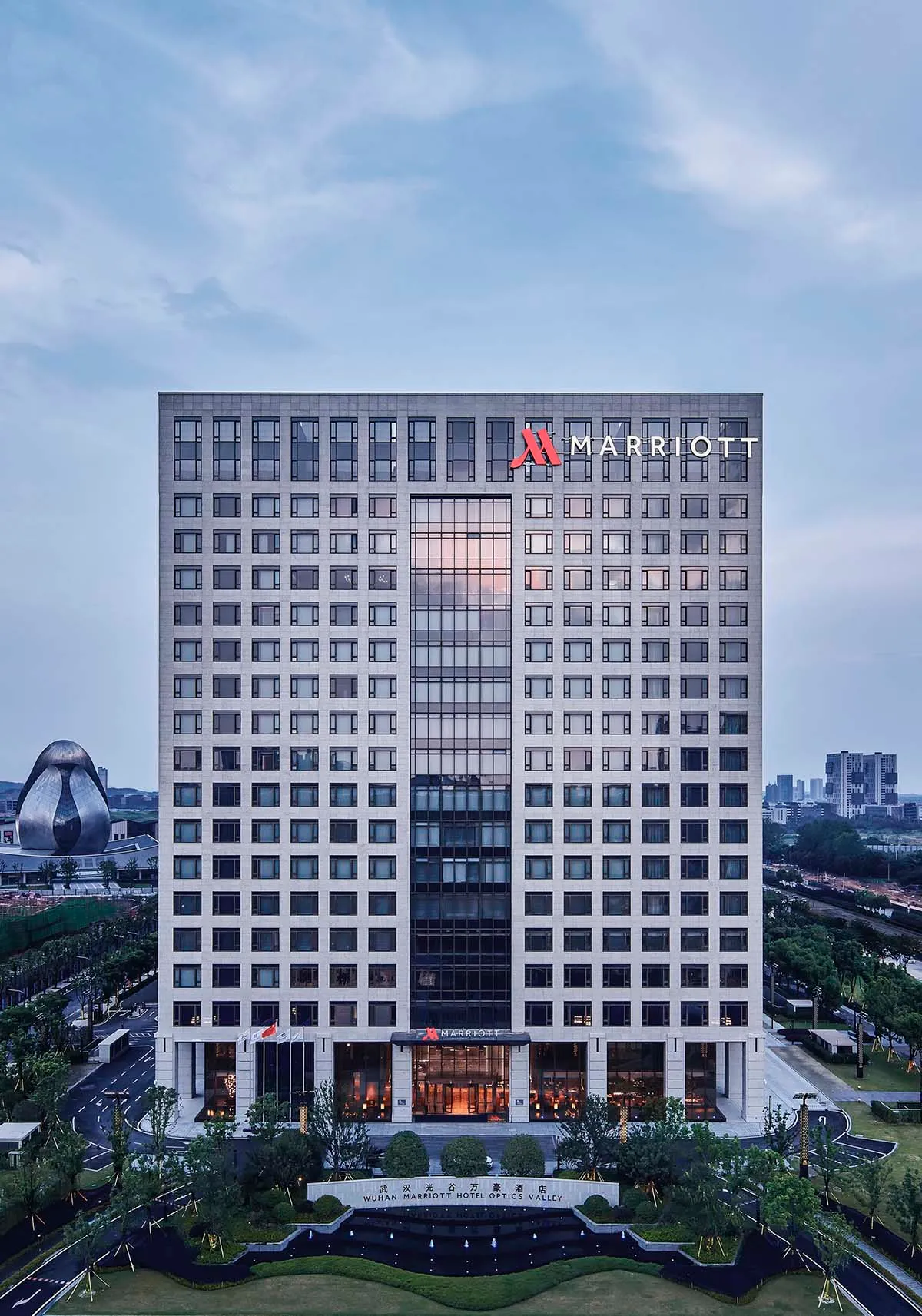 Modern hotel building exterior with glass windows and concrete cladding.
