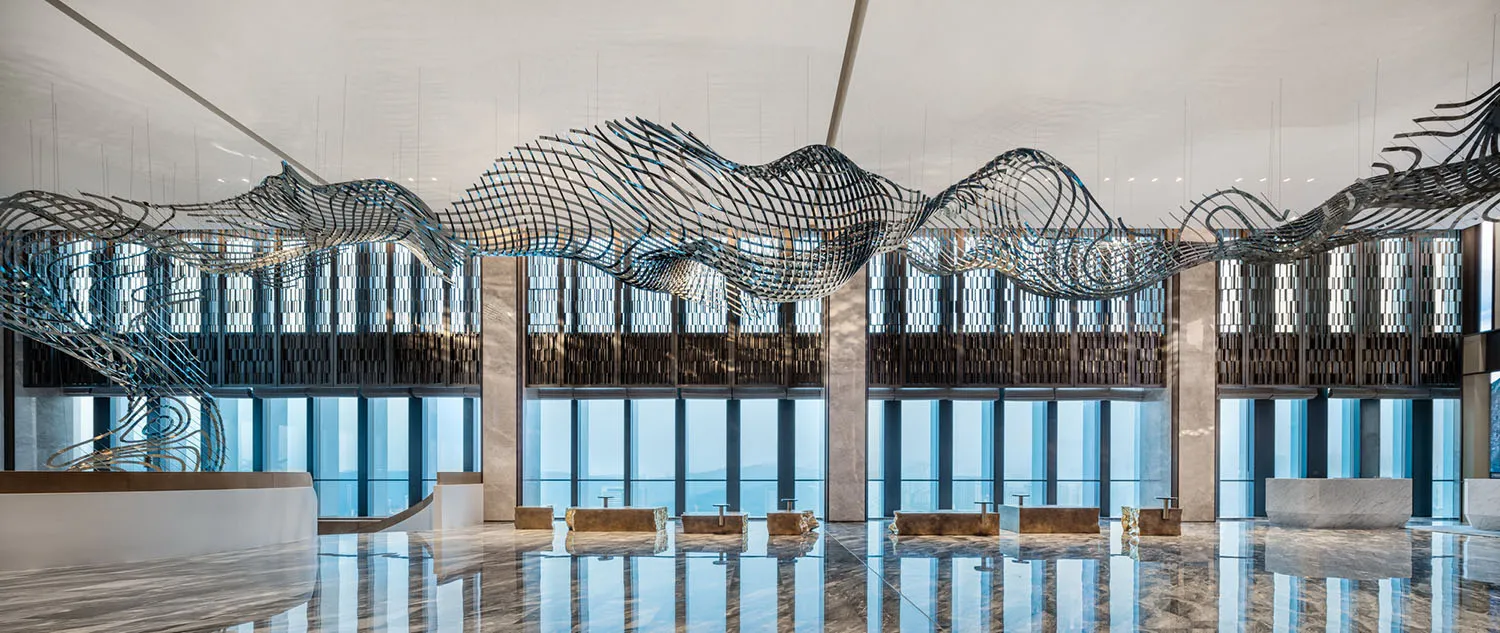 A modern lobby interior featuring a large, intricate metal sculpture