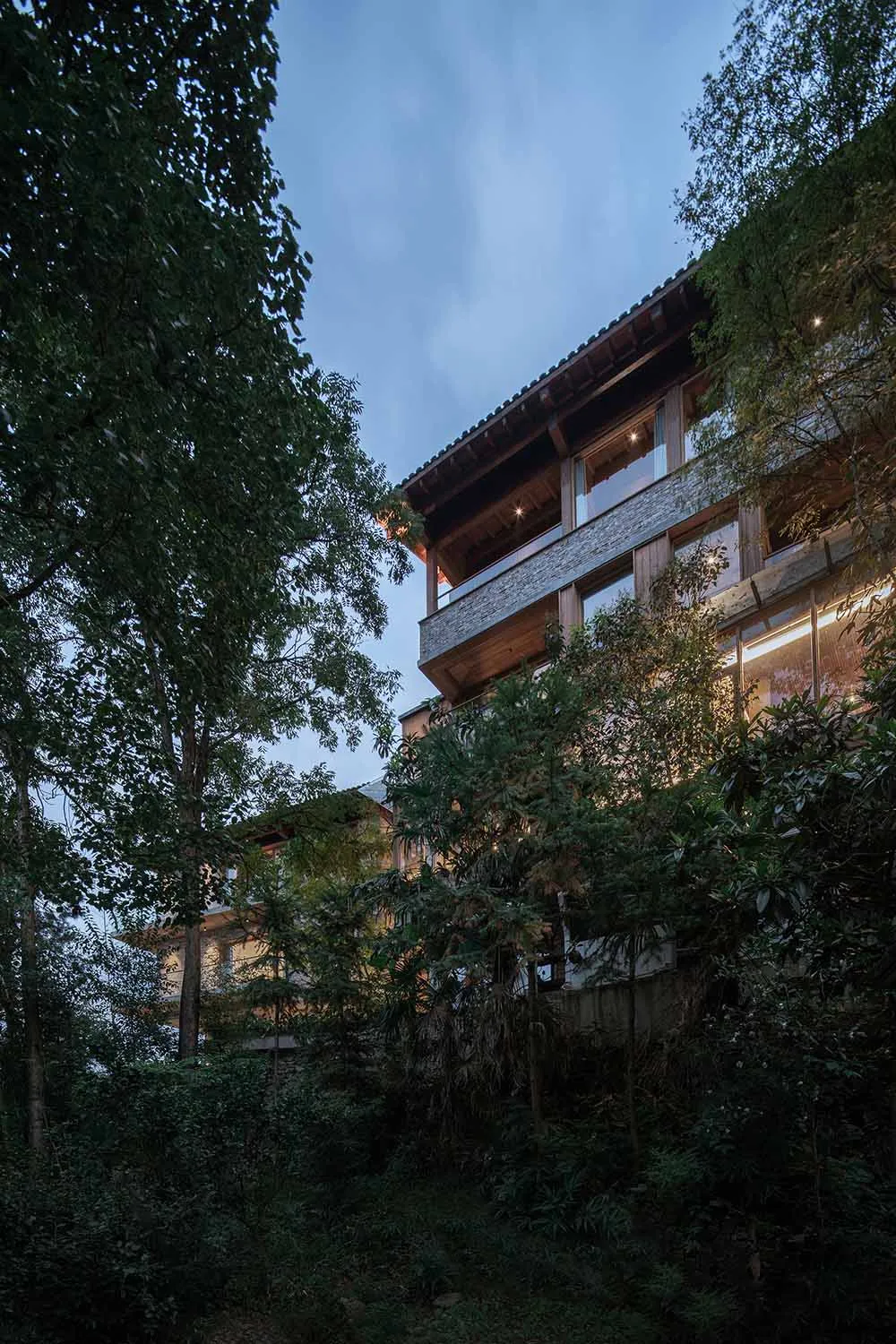 A modern residential interior with wood, stone, and glass exterior.