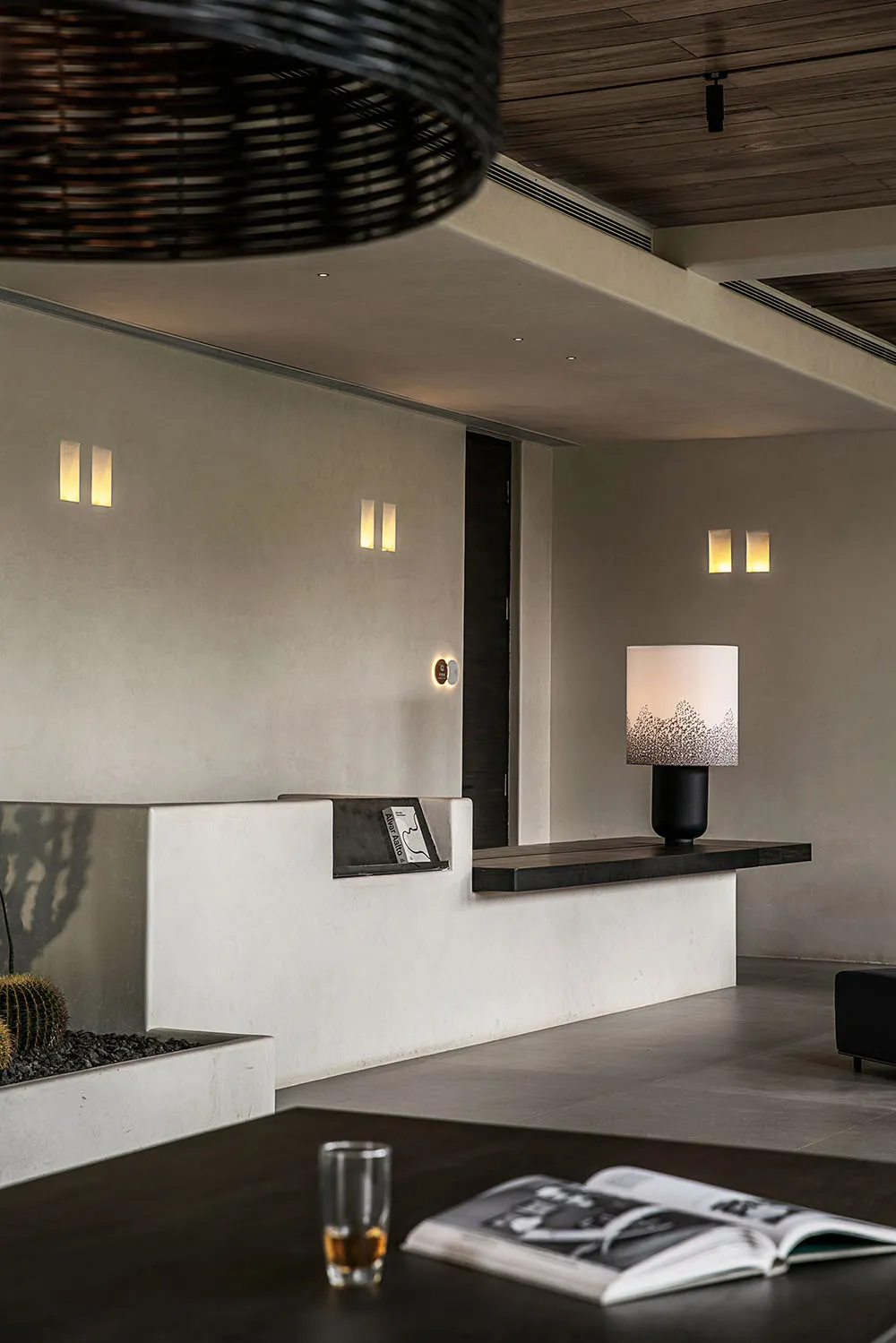A modern living room with concrete surfaces, minimalist decor, and a warm, inviting atmosphere.
