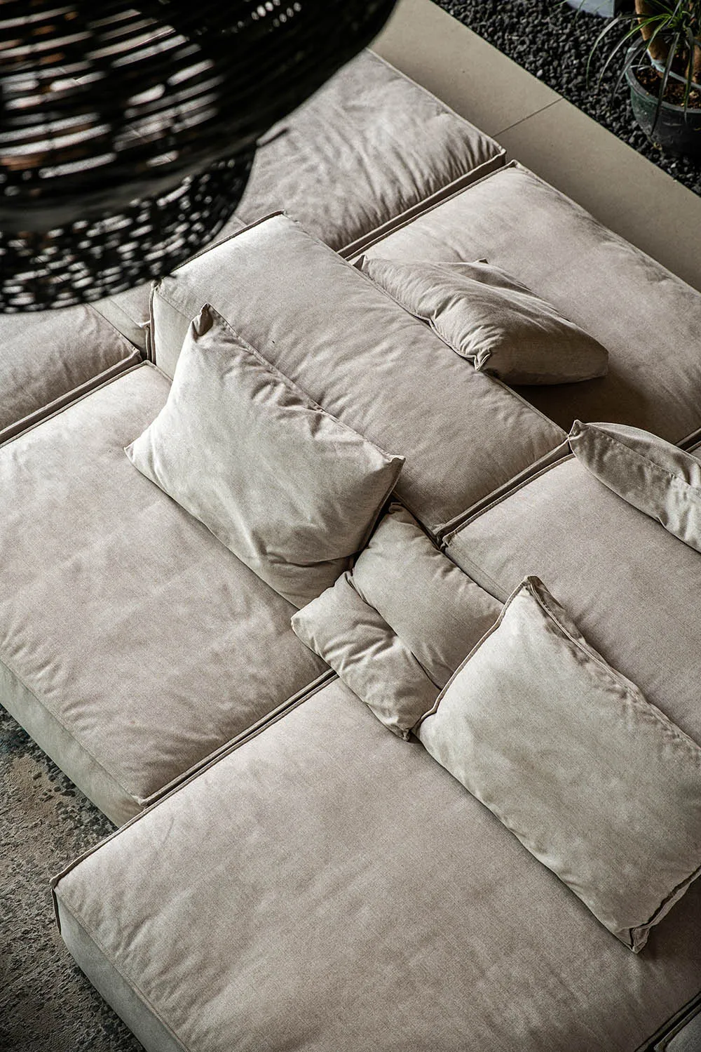 Plush, light gray fabric sofa adorned with multiple cushions in a modern design.