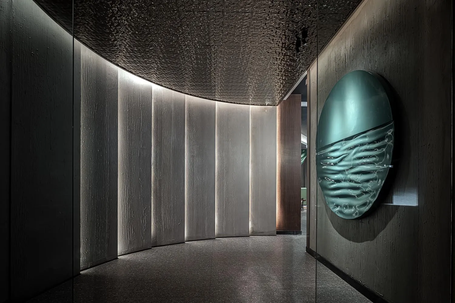 Modern interior featuring textured concrete panels and metallic ampelite elements.