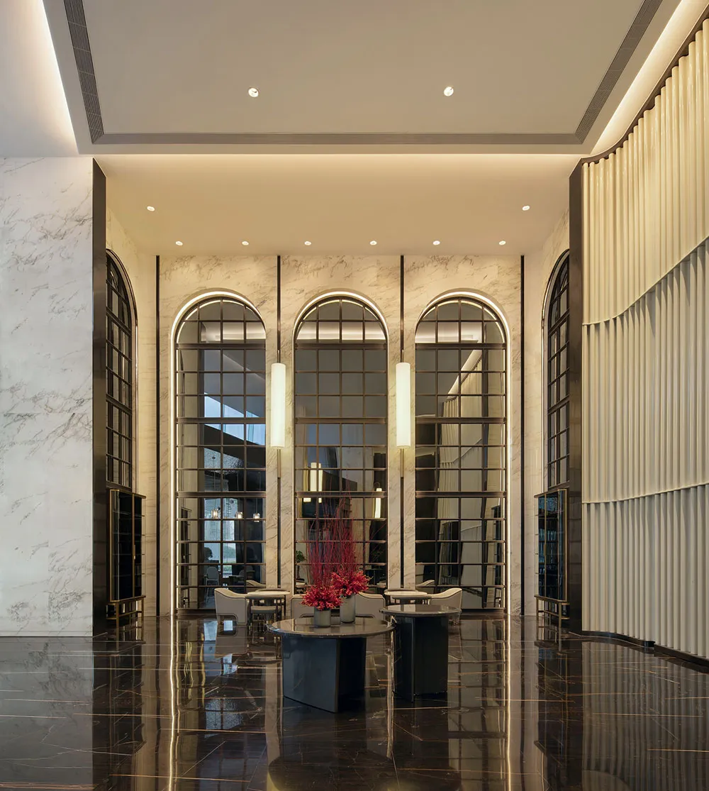 Modern lobby interior with marble walls and glass panels.