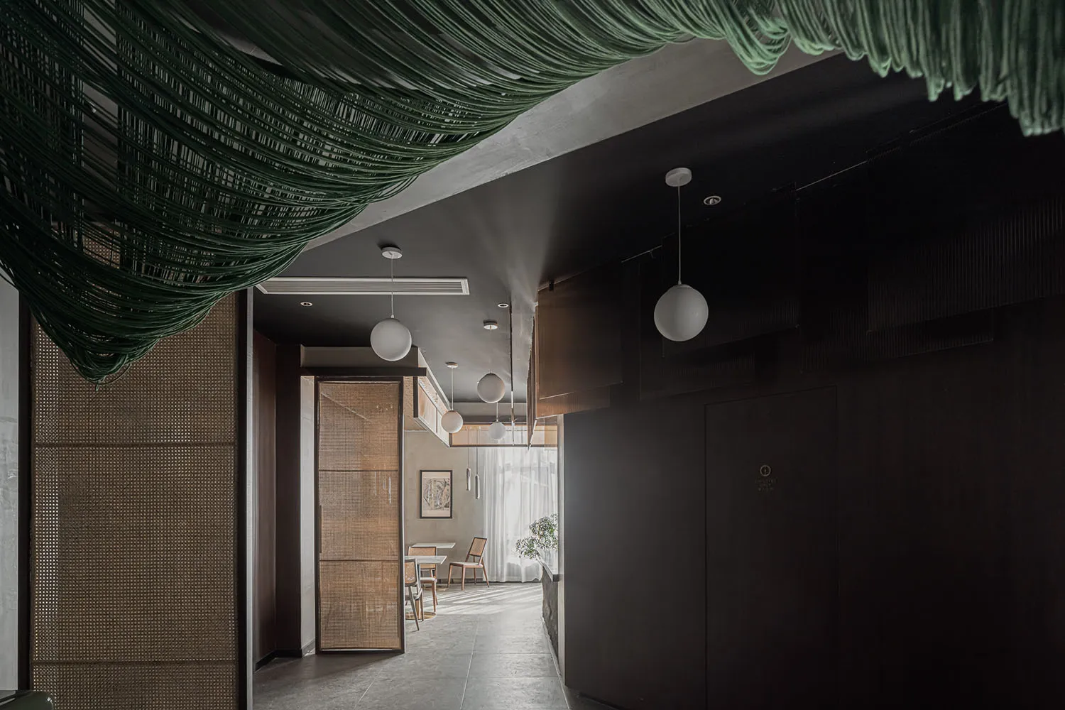 Contemporary restaurant interior with greenery accent and wooden decorative panels.