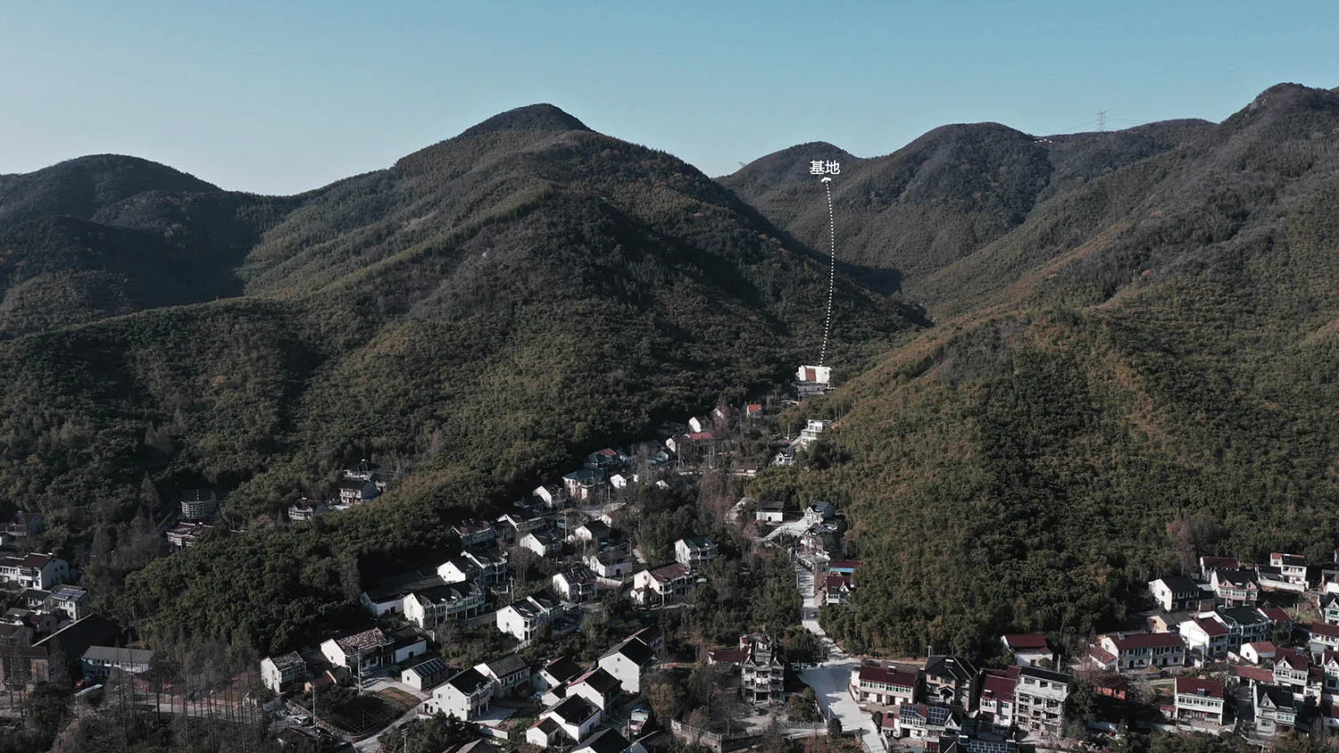 A beautiful aerial view of a mountain village with a lake house nestled among the trees.