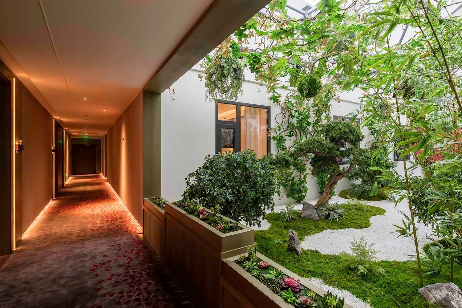 An interior space featuring a green roof garden with concrete structures and lush green vegetation.