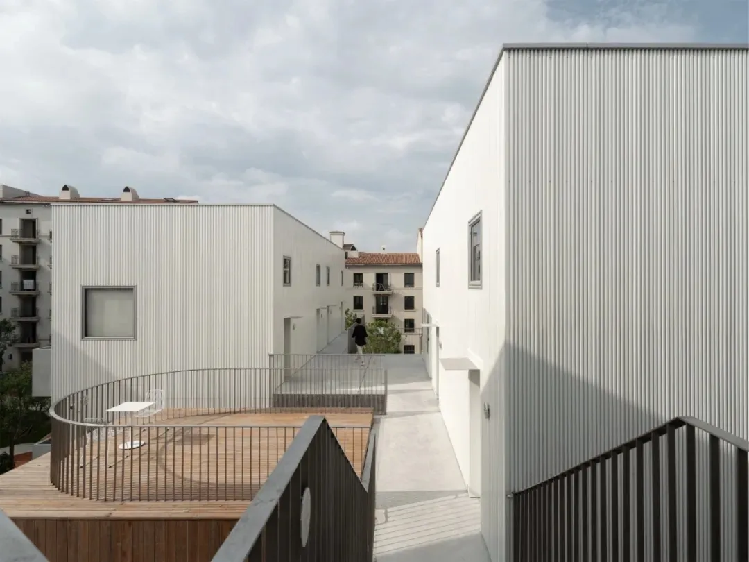Modern minimalist building with metal-clad exterior, featuring clean lines and simple forms.