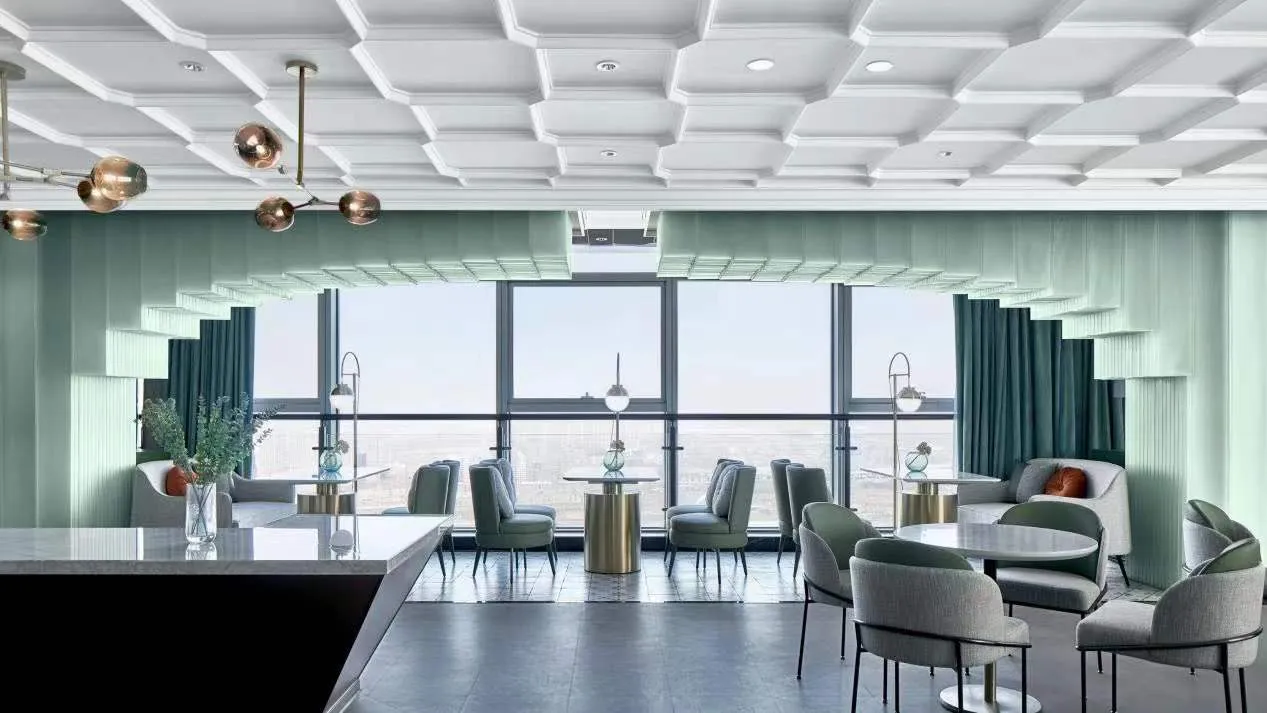 Modern restaurant interior with glass walls, metallic accents, and fabric seating.
