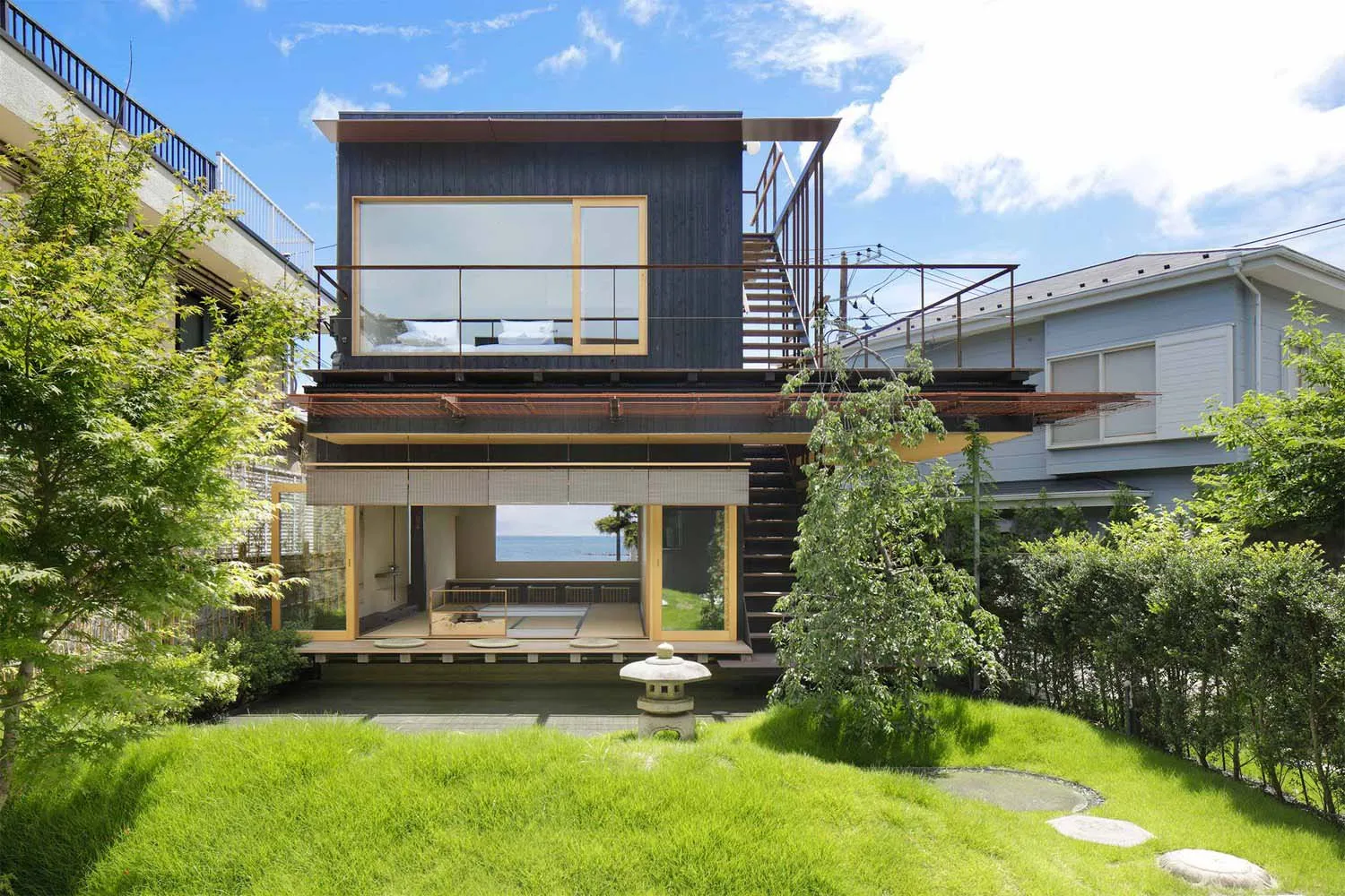 一座現代住宅,外牆採用木質建材,並搭配大型玻璃窗。