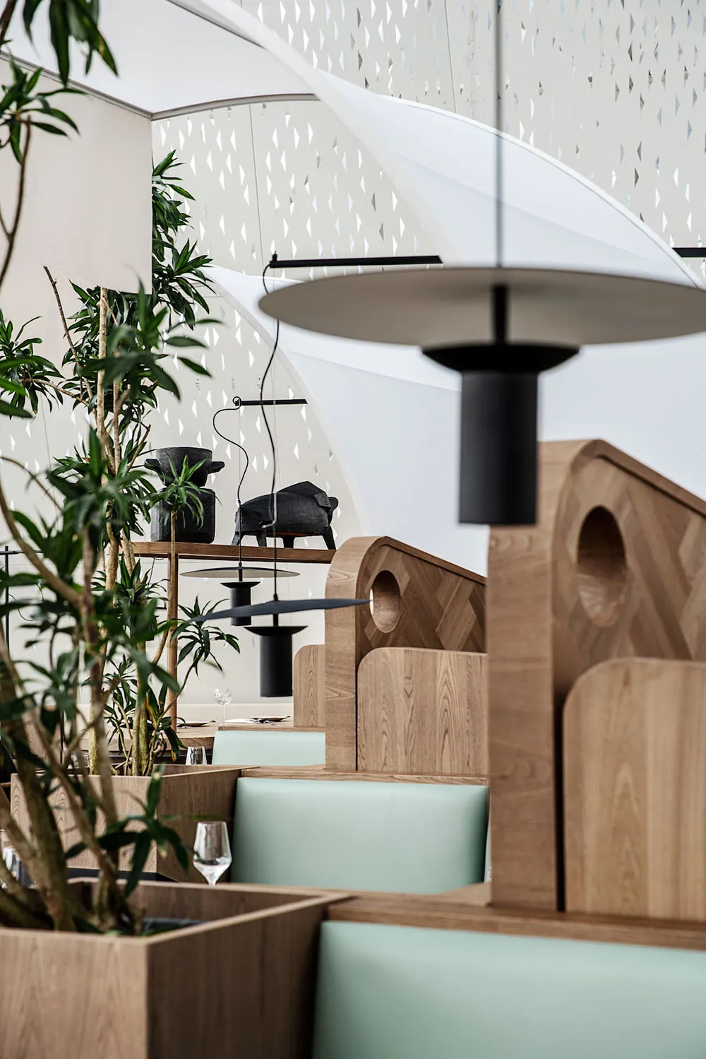 A modern restaurant interior featuring wood-paneled booths and leather seating.