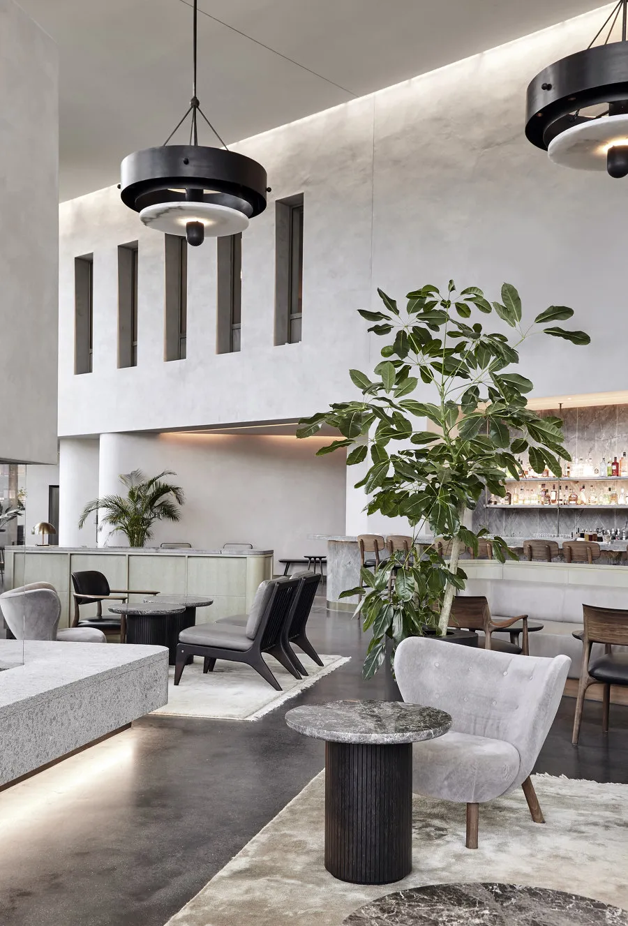 Modern restaurant interior with concrete, marble, and wooden finishes.