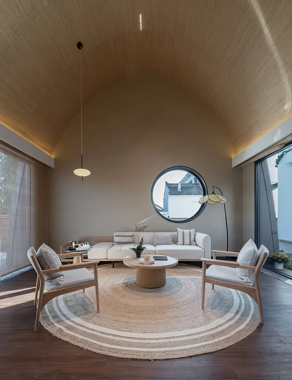 A minimalist living room with wooden furniture, textile accents, and glass elements.