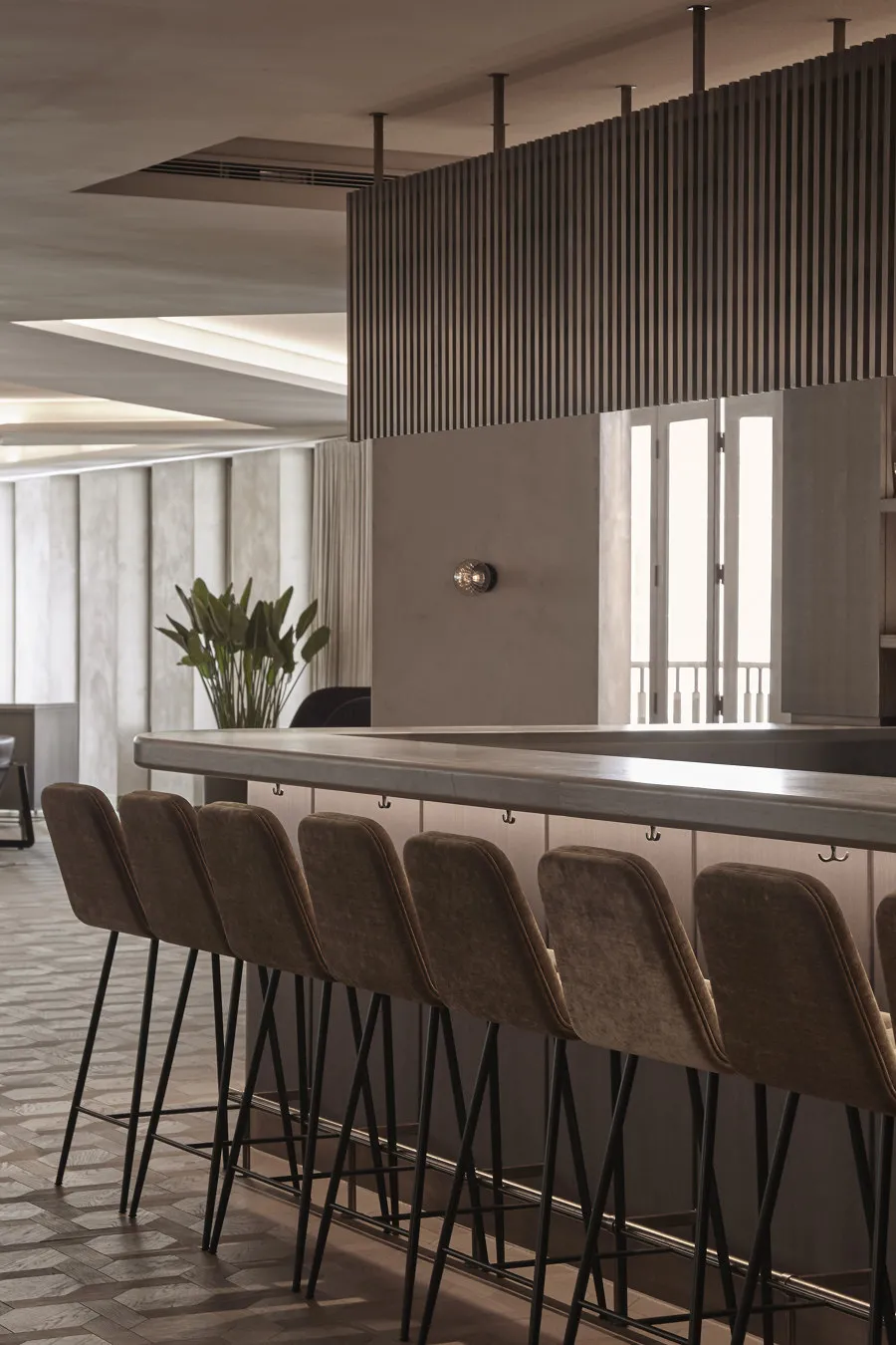 Modern bar interior with concrete countertop and glass partitions.