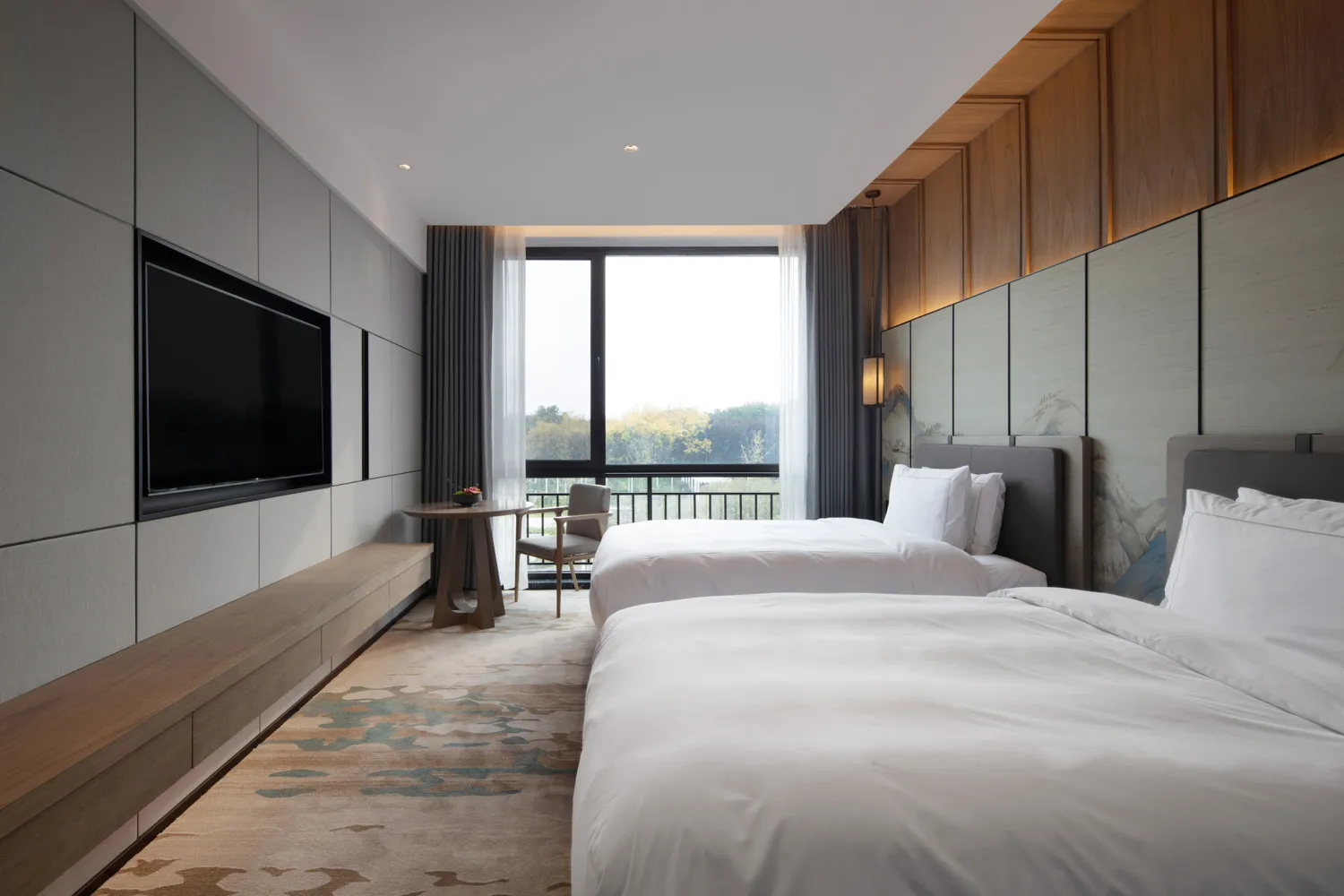 A modern bedroom with two twin beds, wooden headboards, and a television mounted on the wall.