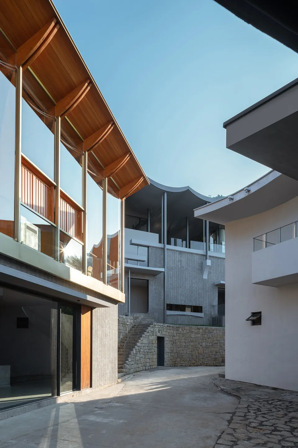 Modern residential living space featuring glass, stone, and concrete materials.