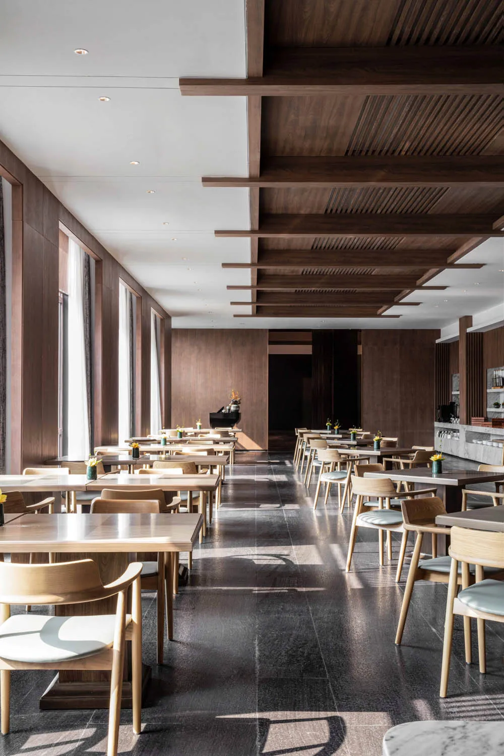 現代餐廳室內,搭配木質餐桌、餐椅及大理石裝飾。