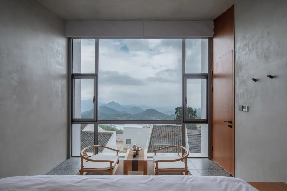 現代臥室配有大型玻璃窗,展示壯麗山景。