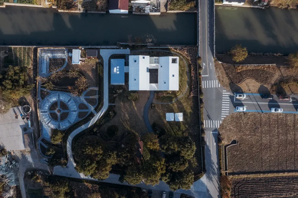 A minimalist residential space with modern design features a curved roof and garden.