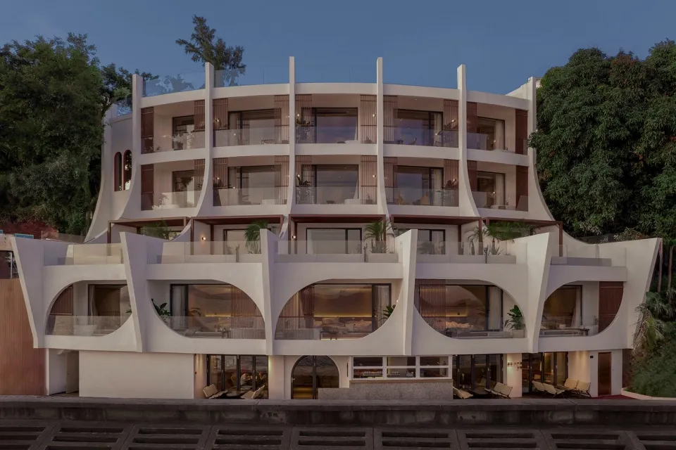 一張展示現代住宅建築的圖像,外牆為混凝土材質,並有曲線陽台。
