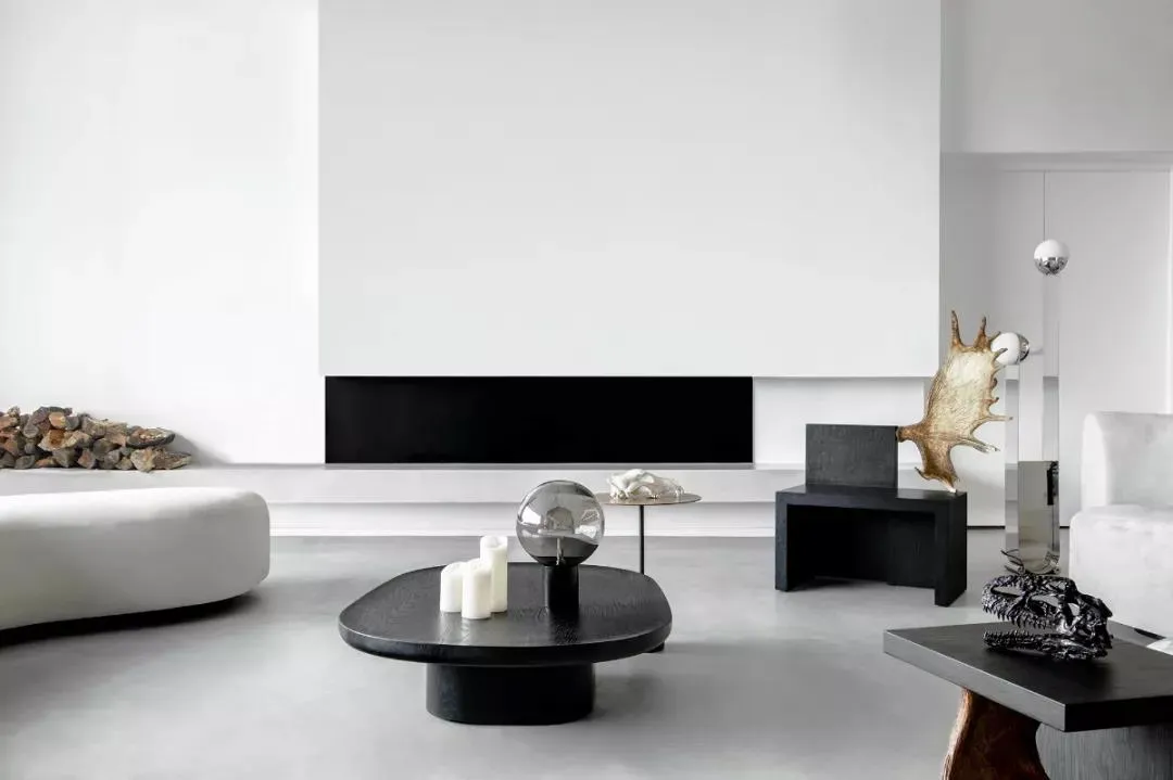Modern minimalist living room with concrete floor, metal and wood furniture, and sleek black accents.