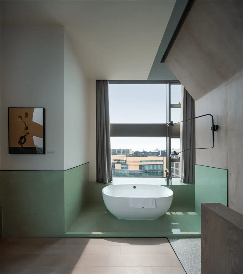 A modern bathroom featuring a glass-enclosed bathtub with a view of the city.