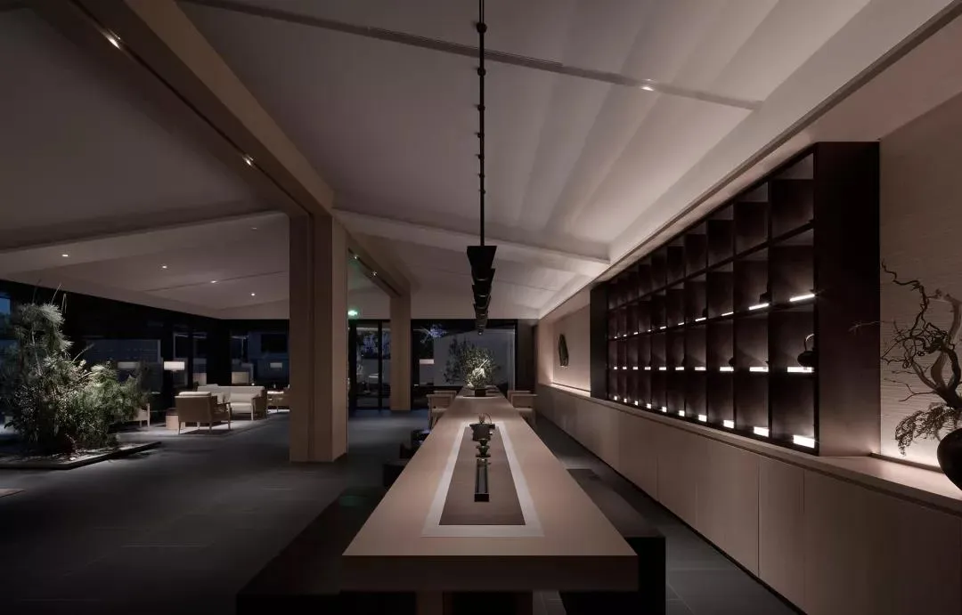 現代酒店大廳,鋪設混凝土地板、木質座椅與淺色金屬點綴。